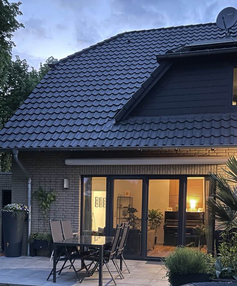 Wohnobjekt mit Terrasse und Garten in der Abenddämmerung