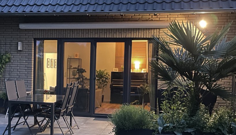 Beleuchtete Terrasse mit bodentiefen Fenstern